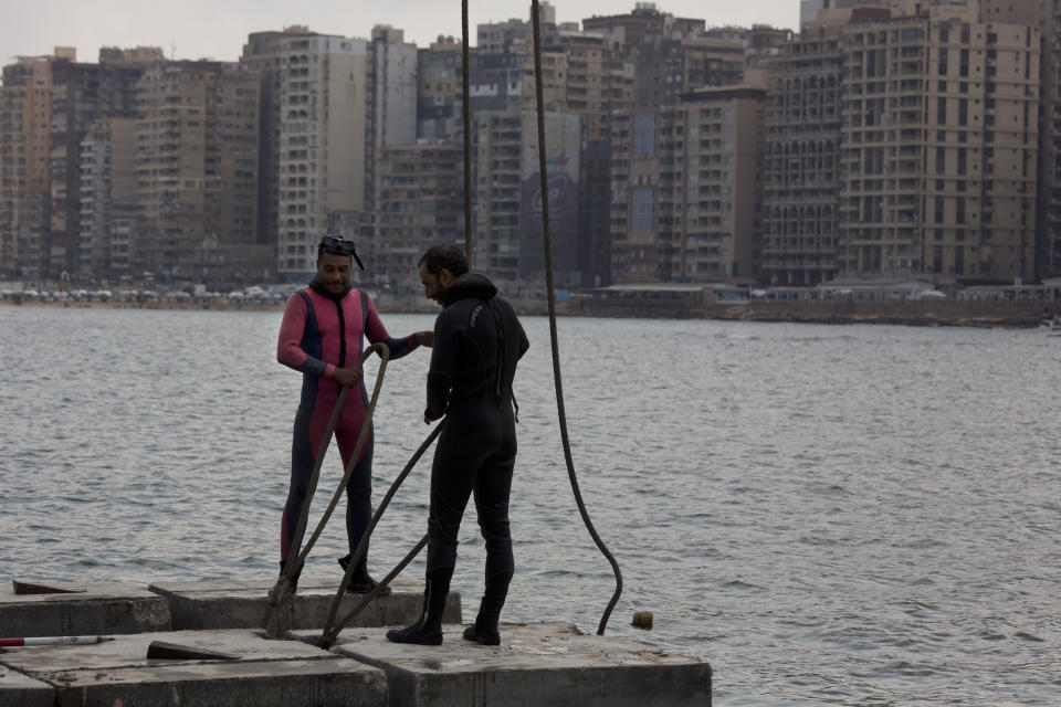 In this Aug. 8, 2019 photo, workers prepare to place cement blocks to stave off rising water levels near the corniche in Alexandria, Egypt. Alexandria, which has survived invasions, fires and earthquakes since it was founded by Alexander the Great more than 2,000 years ago, now faces a new menace from climate change. Rising sea levels threaten to inundate poorer neighborhoods and archaeological sites, prompting authorities to erect concrete barriers out at sea to hold back the surging waves. (AP Photo/Maya Alleruzzo)