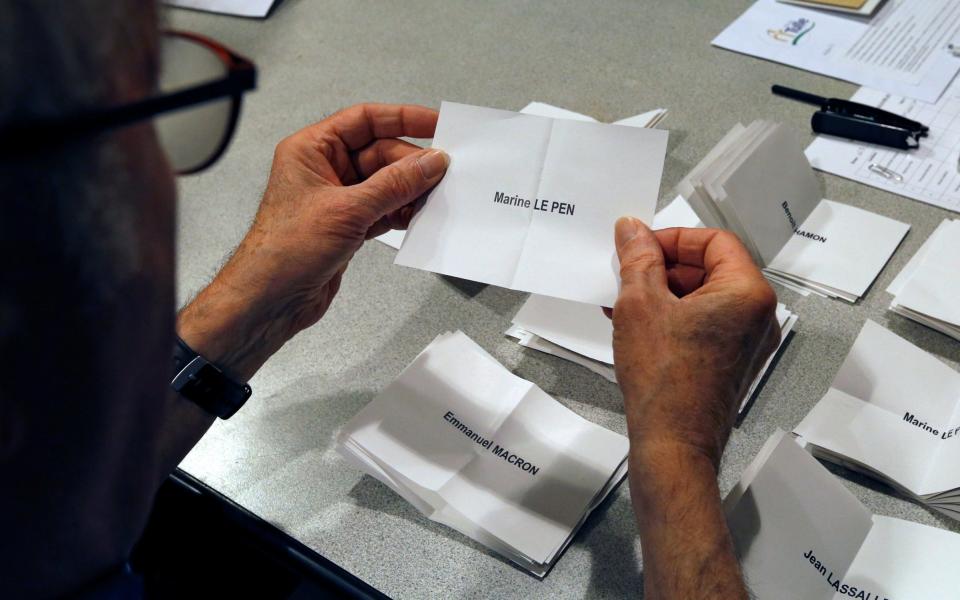 An official counts a ballot showing the name of Marine Le Pen at a polling station in Tulle, central France - Credit:  REGIS DUVIGNAU/ REUTERS