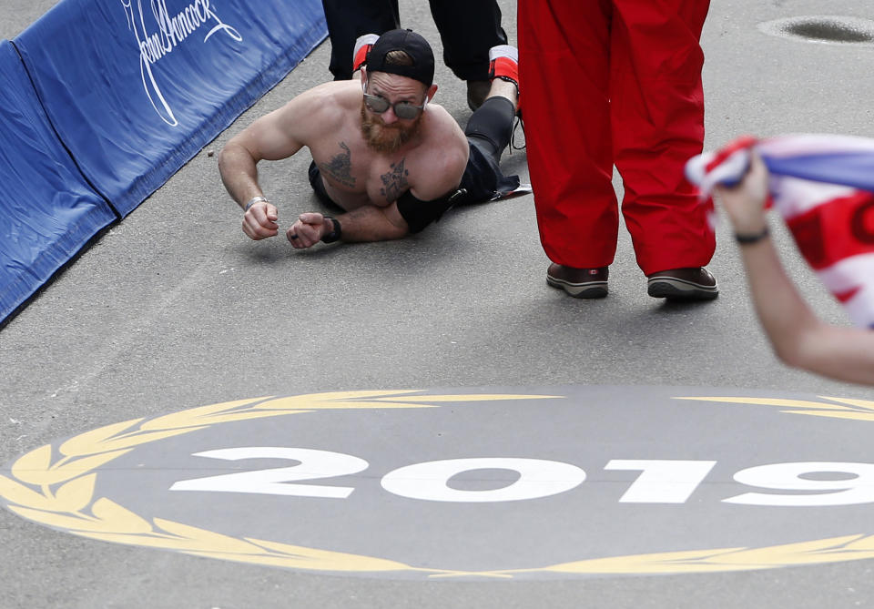 Micah Herndon does a low-to-the-ground Army crawl to cross the finish line. (Photo: Getty Images/Jessica Rinaldi/Globe Staff)