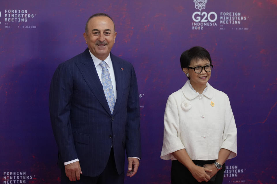 Indonesian Foreign Minister Retno Marsudi, right, greets Turkish Foreign Minister Mevlut Cavusoglu upon arrival at the G20 Foreign Ministers' Meeting in Nusa Dua, Bali, Indonesia, Friday, July 8, 2022. (AP Photo/Dita Alangkara, Pool)