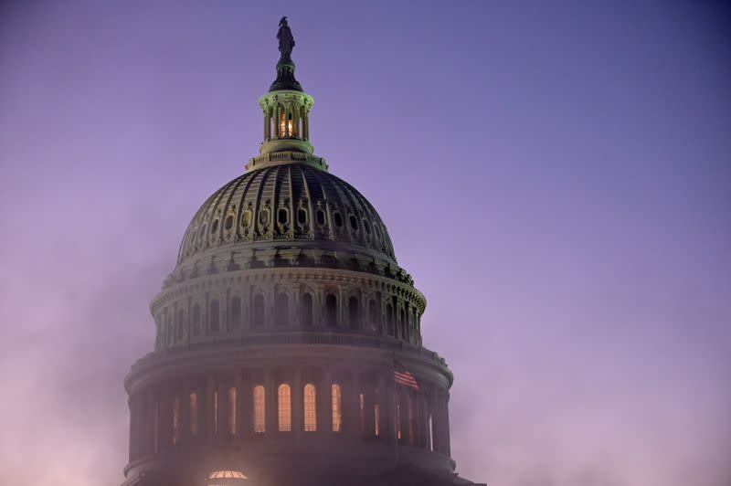 The U.S. Capitol dome is seen through steam from a vent at sunset in Washington