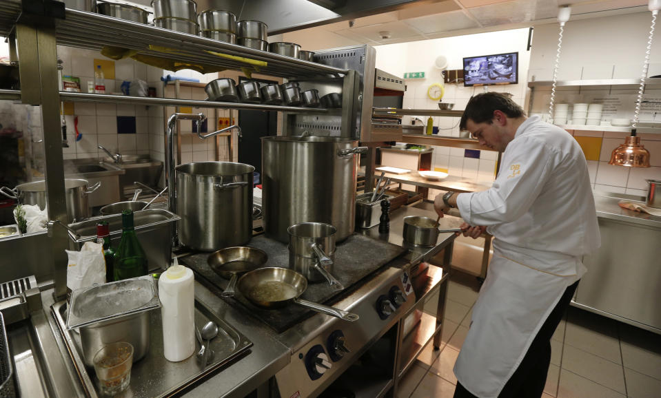 In this picture taken March 6, 2013 Chef Ondrej Soukup prepares a meal in a restaurant at the Zizkov television tower in Prague, Czech Republic. Following its completion in 1992, the 216-meter (236-yard) tall television tower in the Czech capital has become a dominant landmark of the city skyline that offers a breathtaking view of Prague from its restaurant and observation desk. (AP Photo/Petr David Josek)