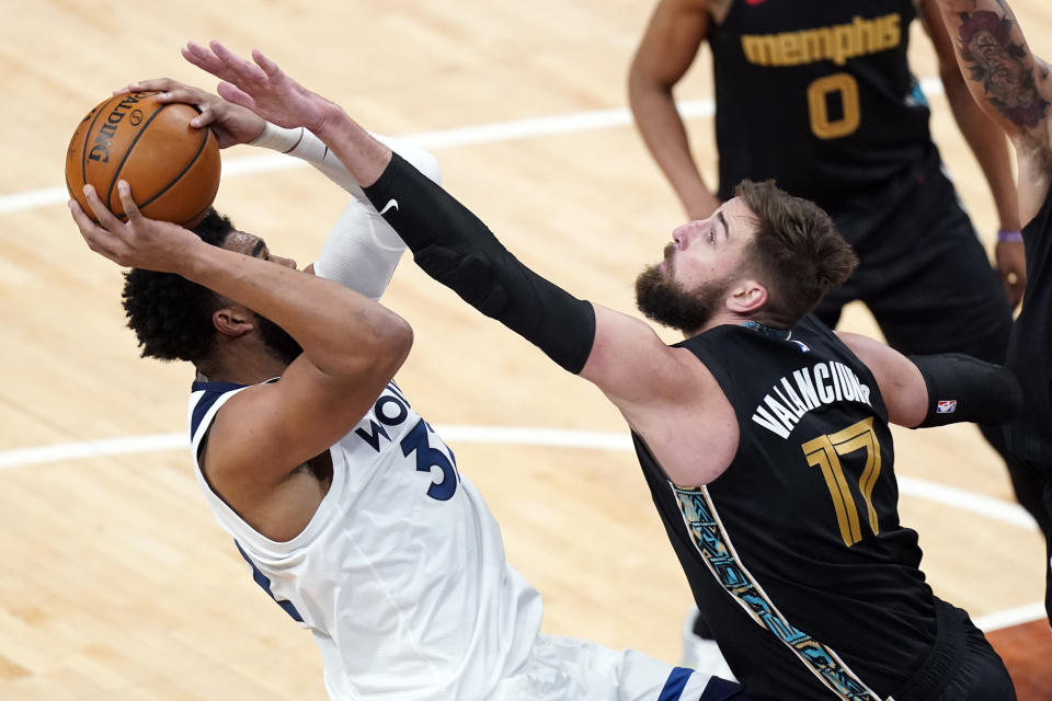 Memphis Grizzlies' Jonas Valanciunas (17) blocks Minnesota Timberwolves' Karl-Anthony Towns (32) in the second half of an NBA basketball game Friday, April 2, 2021, in Memphis, Tenn. (AP Photo/Mark Humphrey)