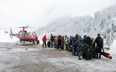  Tourists wait in line at the heliport of Air Zermatt for a flight by airlift into the valley to Raron - Credit:  DOMINIC STEINMANN/Keystone