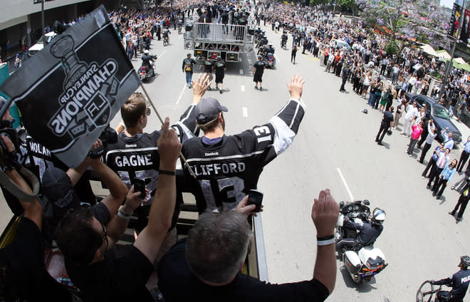 LOS ANGELES, CA - JUNE 14: Simon Gagne #12 and Kyle Clifford #13 of the Los Angeles Kings waves to fans during the Los Angeles Kings Stanley Cup Victory Parade on June 14, 2012 in Los Angeles, California. (Photo by Victor Decolongon/Getty Images)