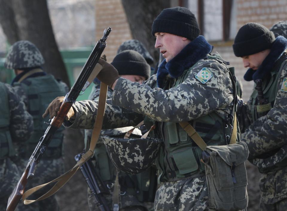 Ukrainian border guards prepare for training at a military camp in the village of Alekseyevka on the Ukrainian-Russian border, eastern Ukraine, Friday, March 21, 2014. Russian President Vladimir Putin has signed a resolution approved by parliament to annex Crimea. (AP Photo/Sergei Grits)