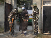 Indian soldiers frisk a voter as he arrives to cast his vote during the first phase of District Development Councils election on the outskirts of Srinagar, Indian controlled Kashmir, Saturday, Nov. 28, 2020. Thousands of people in Indian-controlled Kashmir voted Saturday amid tight security and freezing cold temperatures in the first phase of local elections, the first since New Delhi revoked the disputed region's semiautonomous status. (AP Photo/Mukhtar Khan)