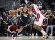 Denver Nuggets forward Aaron Gordon, left, drives past Detroit Pistons forward Saddiq Bey in the first half of an NBA basketball game Sunday, Jan. 23, 2022, in Denver. (AP Photo/David Zalubowski)