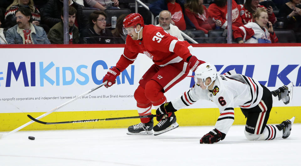 Chicago Blackhawks defenseman Olli Maatta (6) tries to steal the puck from Detroit Red Wings right wing Anthony Mantha (39) during the second period of an NHL hockey game Friday, March 6, 2020, in Detroit. (AP Photo/Duane Burleson)