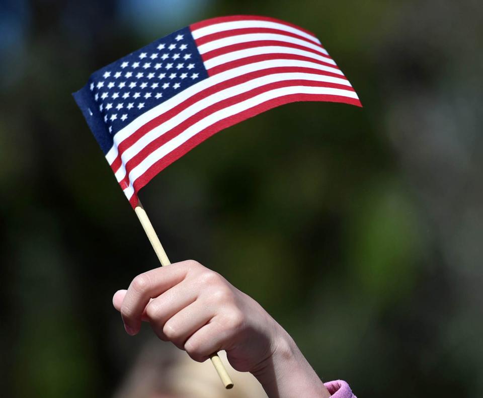 Kindergartener Eliana Shaw, 5, gives a flag wave to visiting military guests at the end of a Memorial Day observance Wednesday at the M.E. Small Elementary School in Yarmouthport. Steve Heaslip/Cape Cod Times