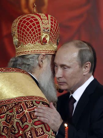 Russian President Vladimir Putin (R) kisses Kirill, Patriarch of Moscow and All Russia, during an Orthodox Easter service in the Christ the Saviour Cathedral in Moscow in this May 5, 2013 file photo. REUTERS/Maxim Shemetov/Files