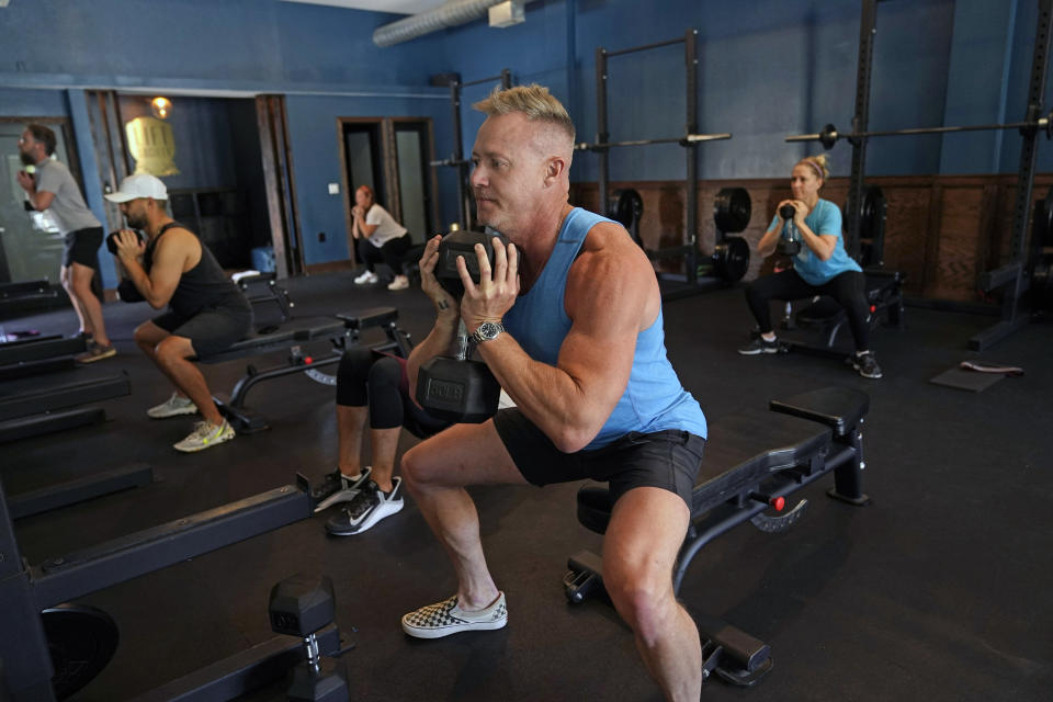 Scott Johnson, foreground in blue, participates in a fitness class at Lift Society Friday, May 21, 2021, in Studio City, Calif. California's top health official says the state no longer will require social distancing and will allow full capacity for businesses when the state reopens on June 15. (AP Photo/Marcio Jose Sanchez)