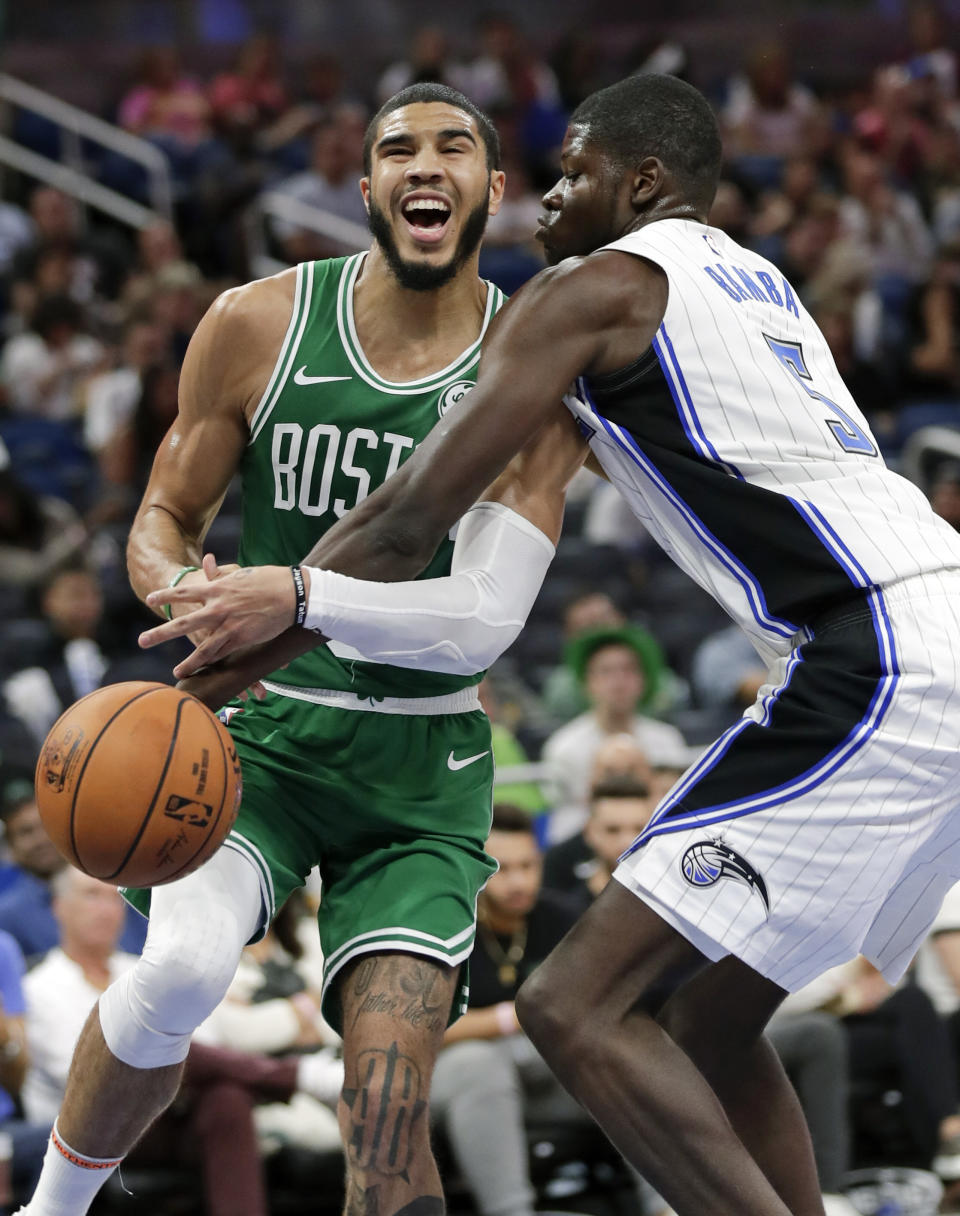 Boston Celtics' Jayson Tatum, left, loses the ball as Orlando Magic's Mo Bamba defends during the second half of an NBA preseason basketball game, Friday, Oct. 11, 2019, in Orlando, Fla. (AP Photo/John Raoux)