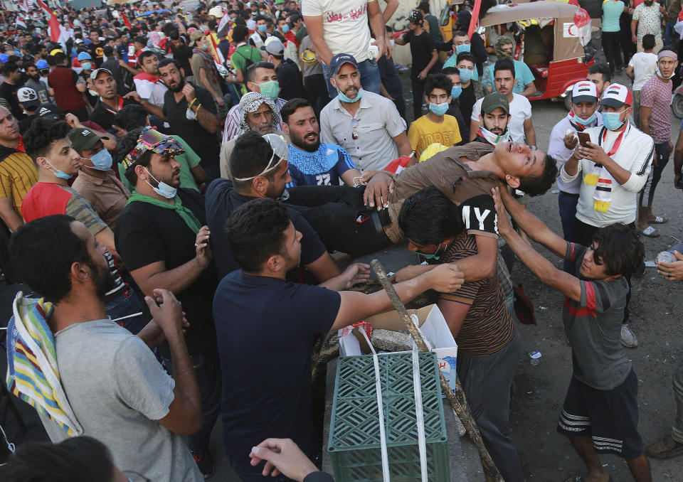 An injured protester is rushed to a hospital during an anti-government protest in Baghdad, Iraq, Friday, Nov. 1, 2019. (AP Photo/Hadi Mizban)