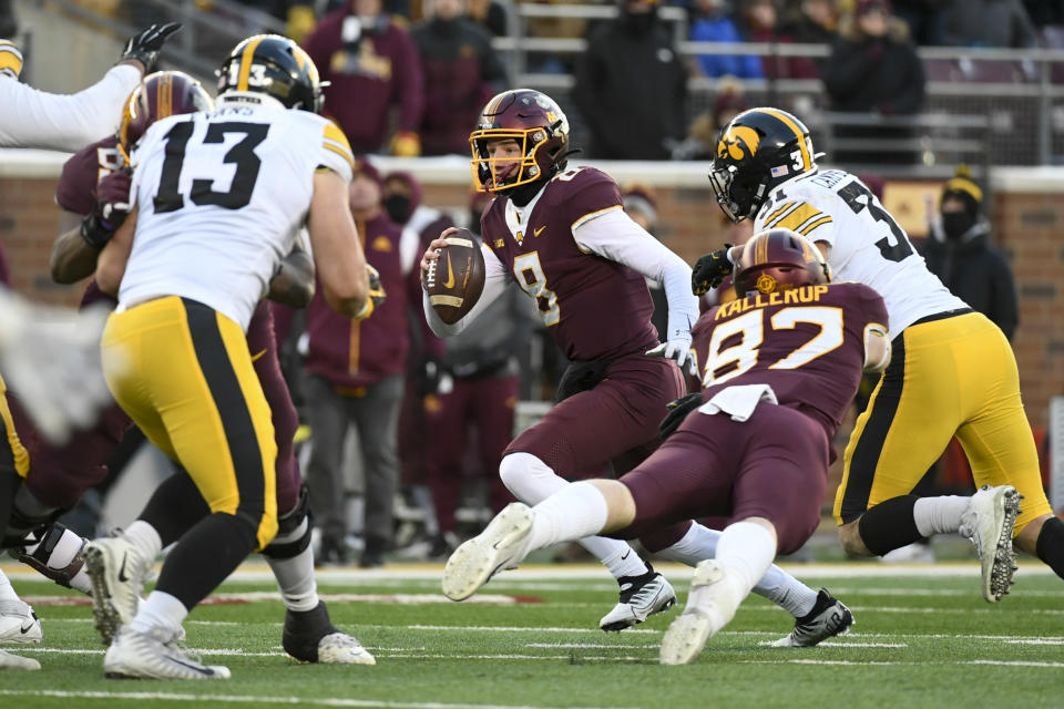 Minnesota quarterback Athan Kaliakmanis (8) scrambles to get away from Iowa defensive back Cooper DeJean (3) during the first half an NCAA college football game on Saturday, Nov. 19, 2022, in Minneapolis. (AP Photo/Craig Lassig)