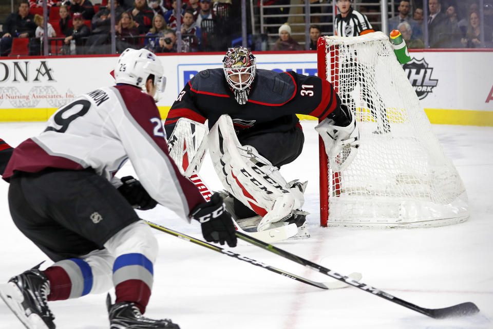 Carolina Hurricanes goaltender Anton Forsberg (31), of Sweden, eyes the puck as Colorado Avalanche's Nathan MacKinnon (29) skates with it during the first period of an NHL hockey game in Raleigh, N.C., Friday, Feb. 28, 2020. (AP Photo/Karl B DeBlaker)