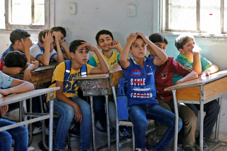 Syrian students from the former rebel held area of Eastern Ghouta attend class at a school in Kafr Batna on September 5, 2018