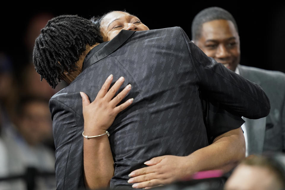 Shaedon Sharpe hugs family members after being selected seventh overall by the Portland Trailblazers in the NBA basketball draft, Thursday, June 23, 2022, in New York. (AP Photo/John Minchillo)