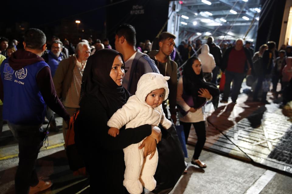 An Afghan mother holds her child upon their arrival from Lesbos island to the port of Piraeus, near Athens, Monday Oct. 7, 2019. In the last 24 hours 668 refugees and migrants have been transferred to mainland Greece from five Greek islands as authorities have accelerated efforts to ease over crowding in the camps. (AP Photo/Thanassis Stavrakis)