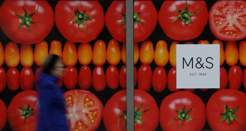 FILE PHOTO: A woman walks past a branch of Marks and Spencer in Altrincham, Britain