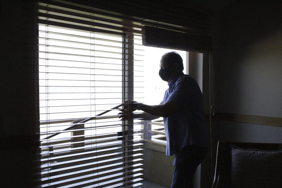 In this Thursday, May 28, 2020, photo, Patrick Nofield, whose company, Escape Lodging, owns and operates four hotels in Cannon Beach, Ore., airs out a guest room at his the flagship property, The Ocean Lodge, due to the coronavirus. With summer looming, Cannon Beach and thousands of other small, tourist-dependent towns nationwide are struggling to balance fears of contagion with their economic survival in what could be a make-or-break summer. (AP Photo/Gillian Flaccus)