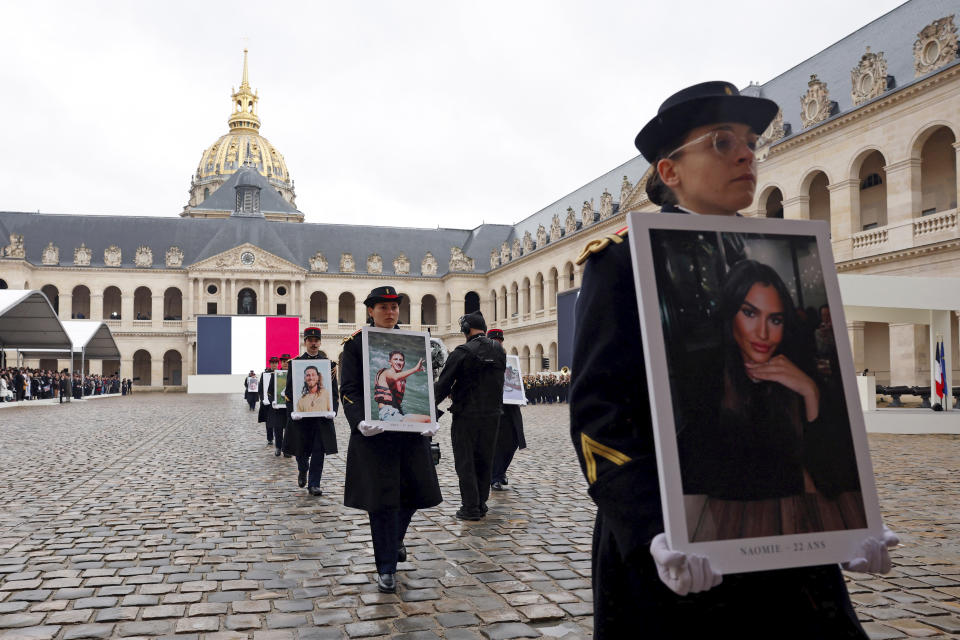 French Republican Guards hold portraits of the French victims of the Oct.7 2023 Hamas' attack, during a ceremony at the Invalides monument, Wednesday, Feb.7, 2024. France is paying tribute to French victims of Hamas' Oct. 7 attack, in a national ceremony led by President Emmanuel Macron four months after the deadly assault in Israel that killed some 1,200 people, mostly civilians, and saw around 250 abducted.(Gonzalo Fuentes/Pool via AP)