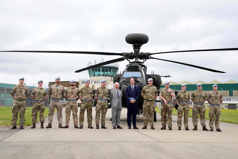 TOPSHOT - El Rey Carlos III de Gran Bretaña entrega oficialmente el cargo de Coronel en Jefe del Cuerpo Aéreo del Ejército al Príncipe Guillermo de Gales de Gran Bretaña delante de un helicóptero Apache en el Centro de Aviación del Ejército en Middle Wallop, Inglaterra, el 13 de mayo de 2024. 