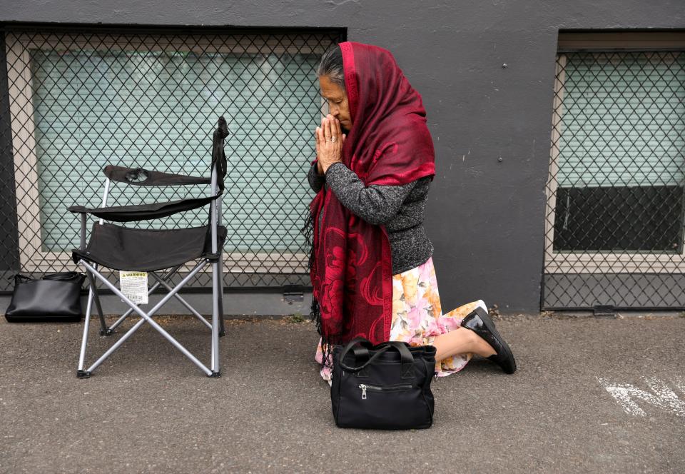 A parishioner kneels in prayer during mass at St. Joseph Catholic Church on Wednesday, Sept. 20, 2023 in Salem, Ore. The church has continued their services under a tent in the parking lot while still recovering from a fire that damaged the building.