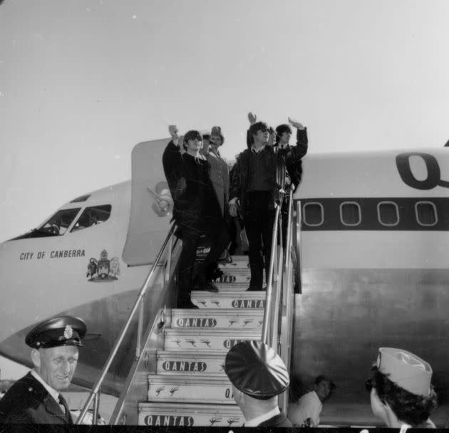 The Beatles wave as they depart on a Qantas flight in 196.