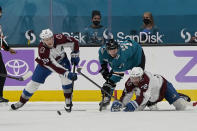 San Jose Sharks defenseman Nikolai Knyzhov, middle, looks toward the puck between Colorado Avalanche center Nathan MacKinnon, left, and Joonas Donskoi during the first period of an NHL hockey game in San Jose, Calif., Monday, May 3, 2021. (AP Photo/Jeff Chiu)