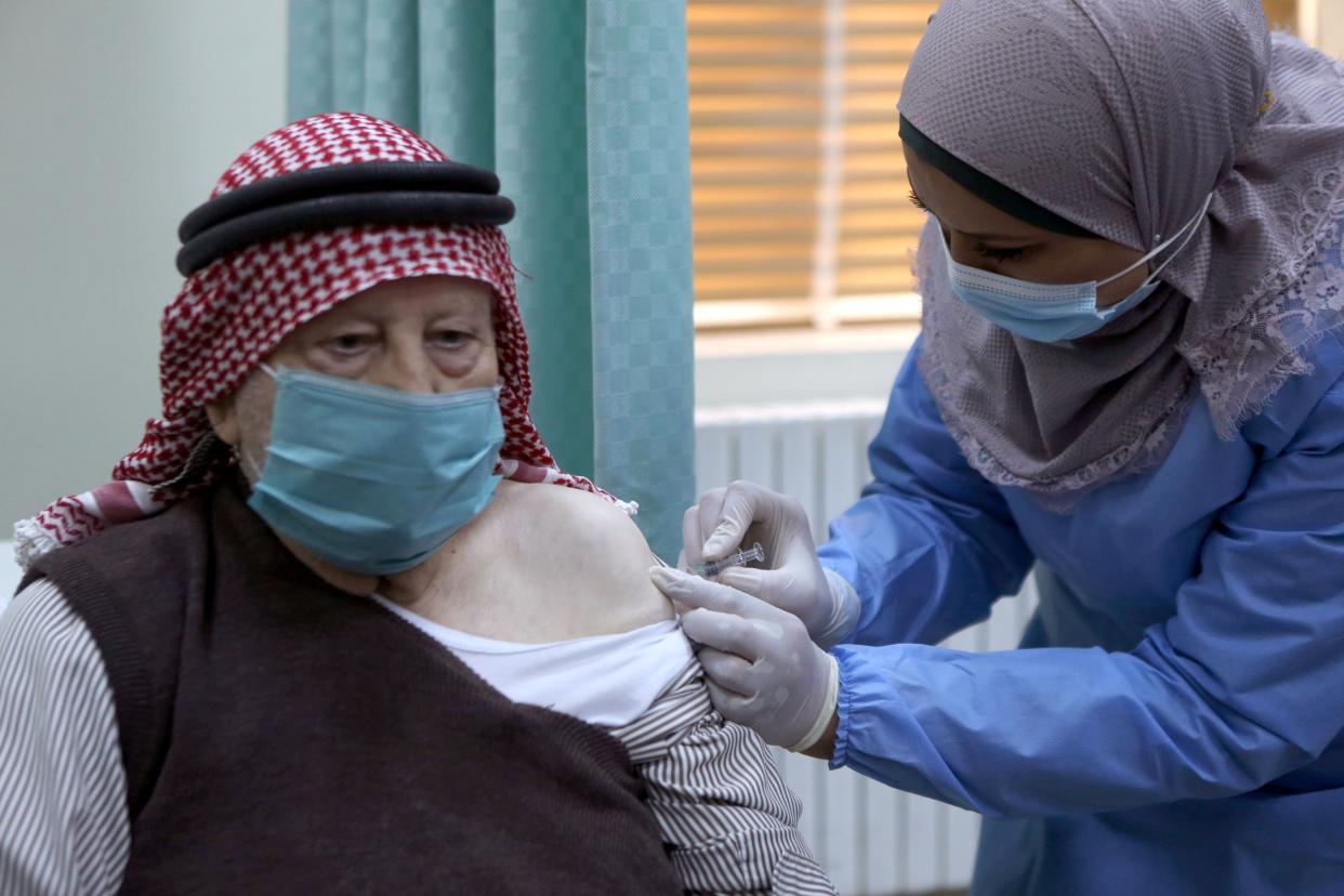 A nurse administers a COVID-19 vaccine to an elderly person as Jordan starts the national vaccination campaign at a special vaccination clinic on Jan. 13, 2021, in Amman, Jordan. Jordan has announced it will deliver two types of vaccine, Cinopharm and Pfizer, and that the priority groups will be the elderly and health staff.