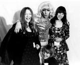 <p>The Who drummer, Keith Moon, poses with fans while dressed in a blonde wig and sequin outfit backstage at a concert in 1972. </p>