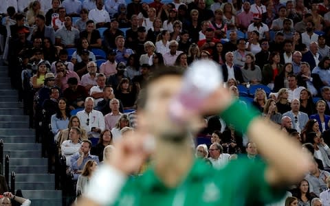 Djokovic takes a sip of his drink while he readies himself for the next game - Credit: Rex