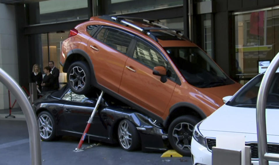 A valet drove the soft-top Porsche Carrera under another vehicle Thursday outside the Hyatt Regency Hotel in Sydney. Source: AP