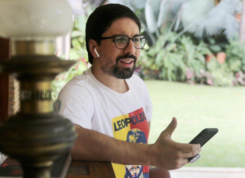 In this Saturday, May 11, 2019 photo, Venezuelan opposition leader Freddy Guevara, exiled at the Chilean ambassador's residence speaks by phone prior a interview with the Associated Press, in Caracas, Venezuela. Guevara, in his first televised interview since taking refuge in the lush diplomatic compound 18 months ago, said as foreign embassies in Caracas fill up with dissidents the world will be forced to take notice of how Nicolas Maduro's clinging to power is not only inflicting more damage on what's left of the rule of law in Venezuela but spilling over its borders as well. (AP Photo/Fernando Llano)