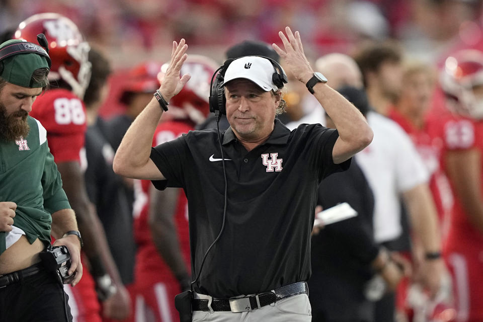Houston coach Dana Holgorsen raises his hand as he walks along the sideline during the first half of an NCAA college football game against TCU Saturday, Sept. 16, 2023, in Houston. (AP Photo/David J. Phillip)