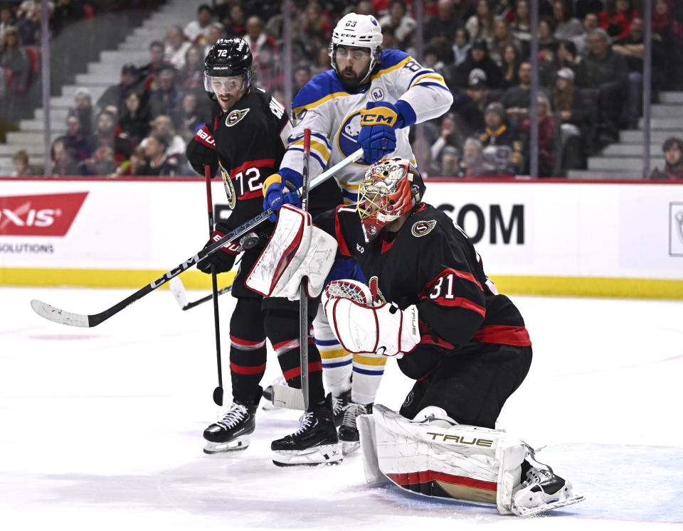 Ottawa Senators goaltender Anton Forsberg (31) makes a blocker-save as Buffalo Sabres right wing Alex Tuch (89) tries for a deflection in front of Senators defenseman Thomas Chabot (72) during first-period NHL hockey game action in Ottawa, Ontario, Sunday, Dec. 31, 2023. (Justin Tang/The Canadian Press via AP)