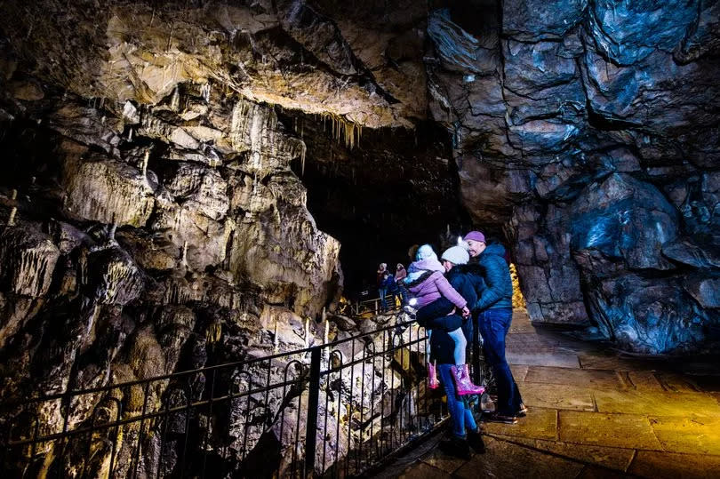 Visitors admiring the cave formation at Poole's Cavern in Buxton