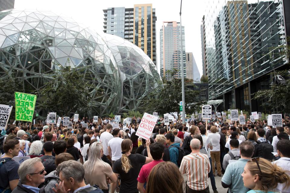 A large group of protesters with signs gather outside of Amazon's headquarters in Seattle.