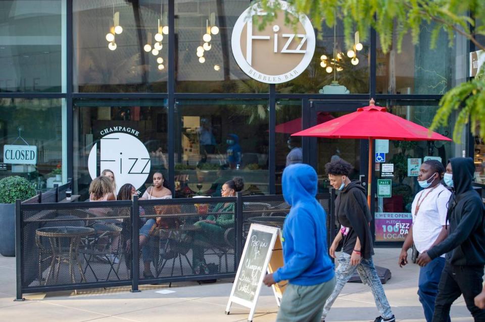 A group walks past Fizz Champagne & Bubbles Bar at Downtown Commons in Sacramento on Sunday, Oct. 10, 2021.