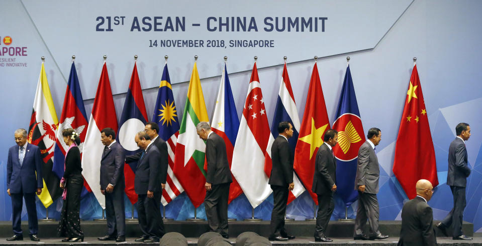 Chinese Premier Li Keqiang, fifth from left, and ASEAN leaders leave the stage following a brief group photo at the start of the ASEAN Plus China Summit in the ongoing 33rd ASEAN Summit and Related Summits Wednesday, Nov. 14, 2018 in Singapore. From left, Prime Minister Mahathir Mohamad of Malaysia, Myanmar Leader Aung San Suu Kyi, President Rodrigo Duterte of The Philippines, Prime Minister Nguyen Xuan Phuc of Vietnam, Chinese Premier Li Keqiang, Prime Minister Lee Hsien Loong of Singapore, Prime Minister Prayuth Chan-ocha of Thailand, Sultan Hassanal Bolkiah of Brunei, Prime Minister Hun Sen of Cambodia, President Joko Widodo of Indonesia. (AP Photo/Bullit Marquez)