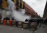 Riot policemen stand behind overturned porta potties during protests in Mexico City September 13, 2013. (REUTERS/Tomas Bravo)