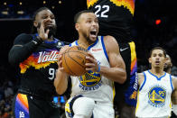 Golden State Warriors guard Stephen Curry drives past Phoenix Suns forward Jae Crowder, left, and center Deandre Ayton (22) during the first half of an NBA basketball game, Tuesday, Nov. 30, 2021, in Phoenix. (AP Photo/Matt York)