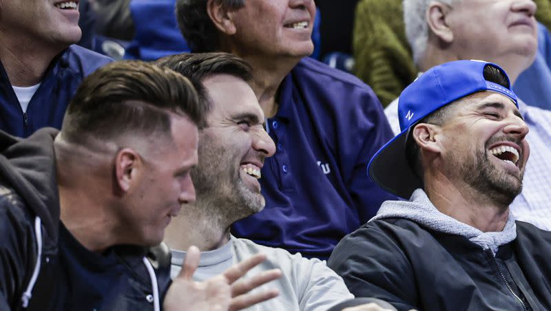 Joe Flacco laughs alongside Austin Collie and Dennis Pitta at a BYU basketball game Saturday, Feb. 10 in Provo.