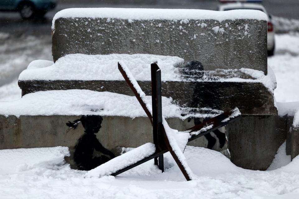 Snow covered graffiti by the British street artist Banksy on Maidan Square in Kyiv, Ukraine (Getty Images)
