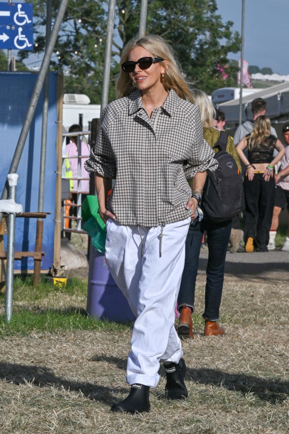 GLASTONBURY, ENGLAND - JUNE 28: Sienna Miller is seen on day one of the Glastonbury Festival wearing Iconic British heritage brand Barbour on June 28, 2024 in Glastonbury, England. (Photo by Jed Cullen/Dave Benett/Getty Images)