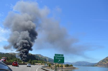 Smoke billows from a derailed oil train near Mosier, Oregon U.S. in this handout photo released to Reuters June 3, 2016. Courtesy of Columbia Riverkeeper/Handout via REUTERS