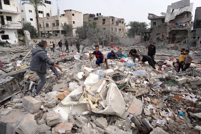 People surrounded by building rubble, conveying aftermath of destruction