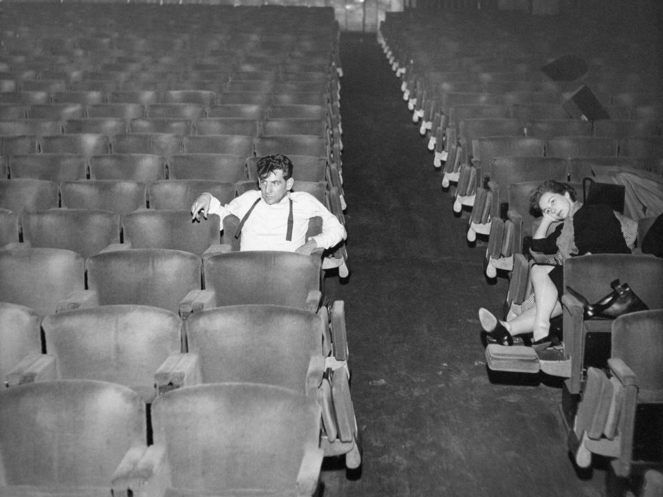 Leonard Bernstein sits in an empty theater in Milan in 1955, with his wife Felicia sitting across the aisle from him.