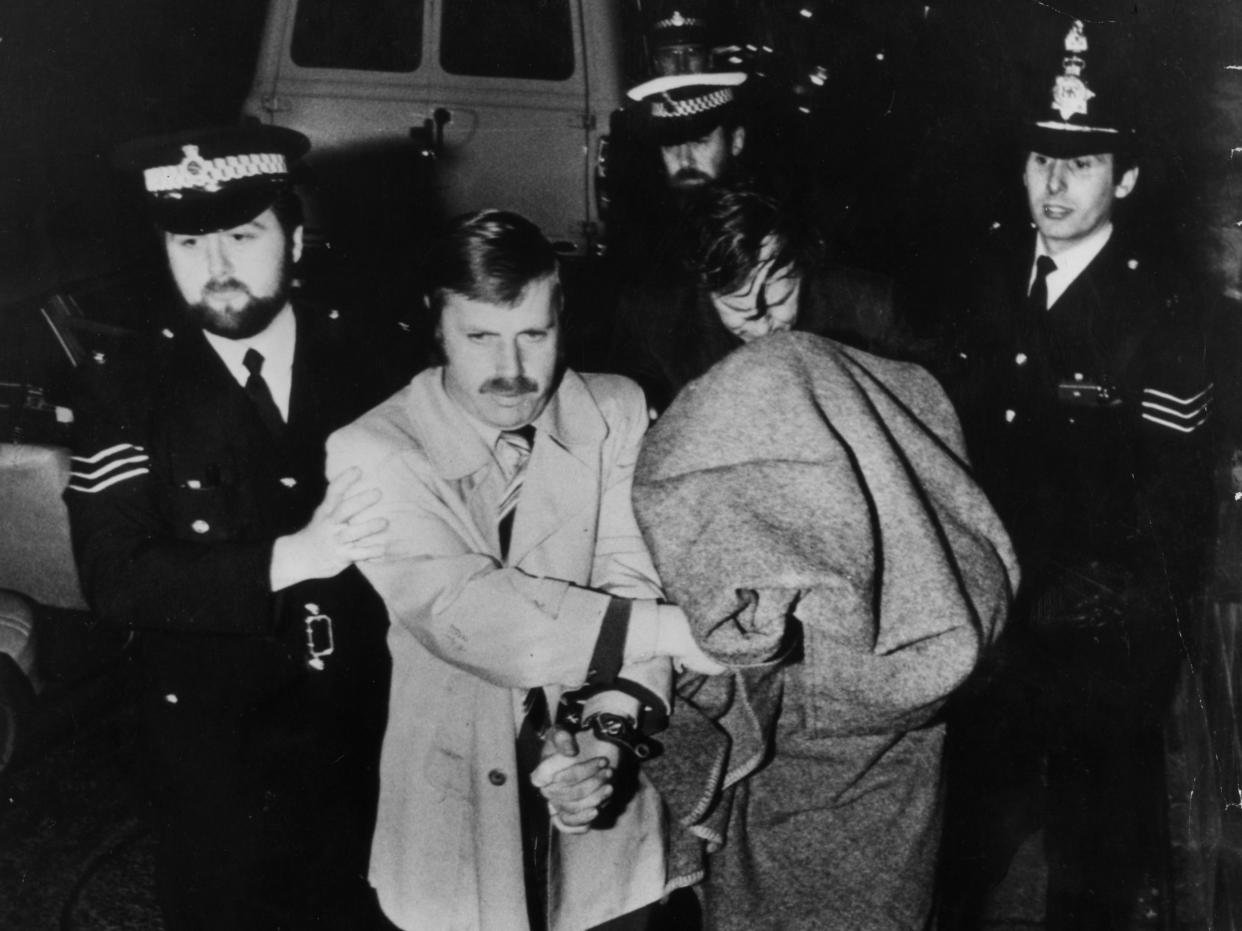 Peter Sutcliffe, aka The Yorkshire Ripper, is brought into Dewsbury Court under a blanket (Getty Images)
